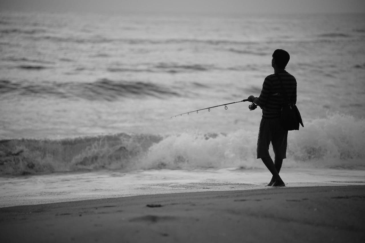 Artistic beach silhouette with fishing rod